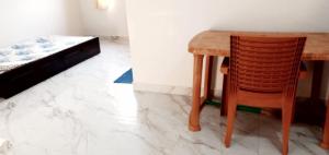 a wooden table and a chair next to a bed at Mayapur in mayapur