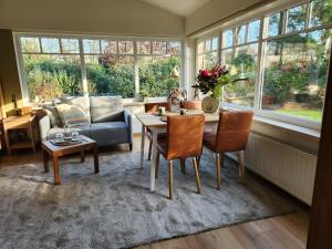 a living room with a table and chairs and a couch at B&B 't Greefsch Geluck in Kalmthout