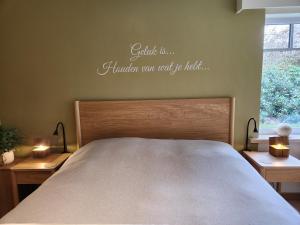 a bedroom with a bed with the words settle inhalley was used to at B&B 't Greefsch Geluck in Kalmthout