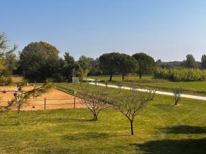 a field of grass with trees and a tennis court at Victoria House pool garden in Fourques
