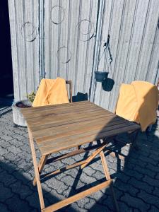 une table de pique-nique en bois et deux chaises devant un bâtiment dans l'établissement Tiny House, à Tüttleben