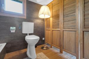a bathroom with a toilet and a lamp at Sérénité Einigen Chalet in Einigen +18 photos