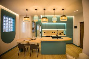 a kitchen with a island with chairs and a table at Solen Suites in Korçë