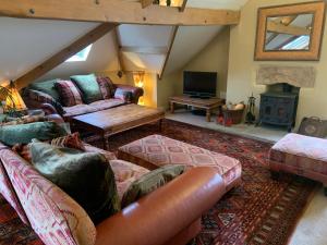a living room with a leather couch and a fireplace at Moorgarth Hall Apartment, Ingleton, Yorkshire Dales in Ingleton