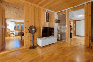 a living room with wood paneling and a flat screen tv at Sérénité Einigen Chalet in Einigen