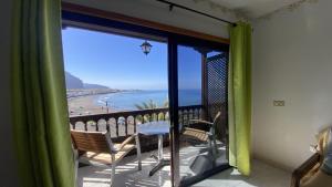 a room with a balcony with a view of the ocean at La Playa 2 B in La Laja