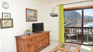 a living room with a television on a wooden dresser at La Playa 2 B in La Laja