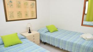 two twin beds in a room with a mirror at La Playa 2 B in La Laja