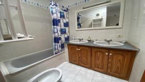 a bathroom with two sinks and a tub and a toilet at La Playa 2 B in La Laja +48 photos