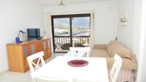a living room with a couch and a table and chairs at La Playa 2 A in La Laja