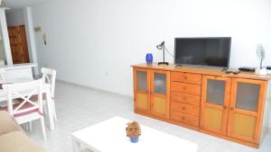a living room with a television on a wooden dresser at La Playa 2 A in La Laja