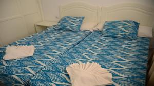 a bed with blue and white sheets and pillows at La Playa 2 A in La Laja