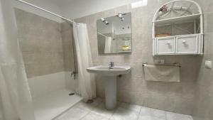 a white bathroom with a sink and a shower at La Playa 2 A in La Laja +32 photos