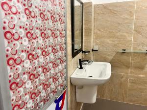 a bathroom with a sink and a shower curtain at River Side Guest House in Hatton