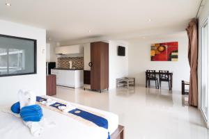 a living room with a couch and a kitchen at Patong hillside Condo with pool, bar, parking in Patong Beach