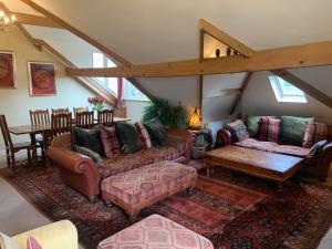 a living room with couches and a table at Moorgarth Hall Apartment, Ingleton, Yorkshire Dales in Ingleton