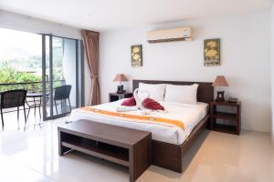 a bedroom with a bed and a balcony at Patong hillside Condo with pool, bar, parking in Patong Beach +38 photos