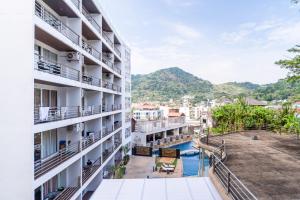 an apartment building with a pool and mountains in the background at Patong hillside Condo with pool, bar, parking in Patong Beach