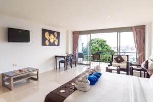 a room with a bed and a living room at Patong hillside Condo with pool, bar, parking in Patong Beach