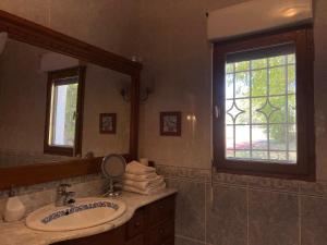 a bathroom with a sink and a mirror and a window at Casablanca in Candeleda
