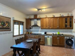 a kitchen with wooden cabinets and a wooden table with a dining room at Casablanca in Candeleda