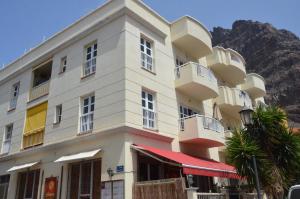 a white building with a mountain in the background at Paquita in La Laja