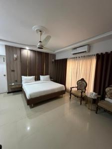 a bedroom with a bed and a chair in it at Comfort Lodge in Karachi