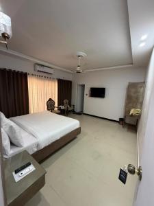 a bedroom with a bed and a tv in it at Comfort Lodge in Karachi