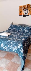 a bed in a room with a blue and white blanket at JuLuc Trelew dpto 1 TUCCI in Trelew