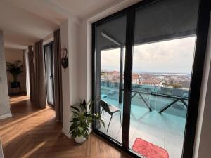 ein Zimmer mit großem Fenster und Blick auf einen Pool in der Unterkunft Panoramic Blue in TÄƒuÅ£ii MÄƒgheruÅŸ