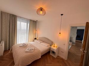 ein Schlafzimmer mit einem Bett, auf dem zwei Handtücher liegen in der Unterkunft Panoramic Blue in TÄƒuÅ£ii MÄƒgheruÅŸ + 29 Fotos