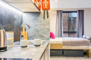 a room with a bed and a kitchen with a sink at Central Studios In Lincoln with Free Grab&Go Breakfast in Lincoln