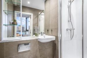 a bathroom with a sink and a mirror and a shower at Central Studios In Lincoln with Free Grab&Go Breakfast in Lincoln