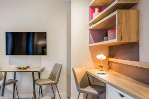 a room with a desk and a table and chairs at Central Studios In Lincoln with Free Grab&Go Breakfast in Lincoln
