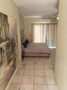 a bedroom with a bed and a painting on the wall at Claypot Guesthouse in Northam