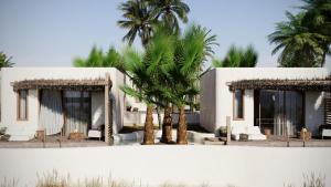 a white building with palm trees in front of it at Eden Island in Agia Paraskevi