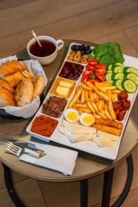 a table with a plate of food with french fries and dips at Inn City Park Hotel in Burunabat +43 photos