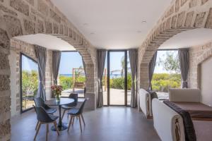 a living room with a table and chairs with a view of the ocean at The Charming Lonno Lodge Watamu in Watamu