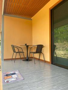 a patio with two chairs and a table and a window at The sun homestay01 in Ko Kood