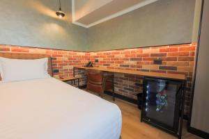a bedroom with a brick wall and a bed and a fireplace at Hotel Gorenje in Prishtinë +11 photos