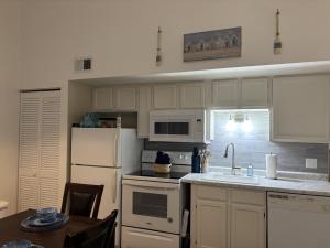 a kitchen with white cabinets and a white refrigerator at Branson Lakeside Getaway in Branson