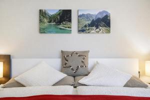 a bedroom with three pictures on the wall above a bed at Alpinum Residence Lungau Ferienwohnung mit Garten in Tamsweg