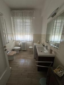 a bathroom with a sink and a toilet and a mirror at Le Casette di Elfo in Grosseto