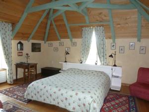 a bedroom with a bed and a red chair at Chambres d'Hôtes du Hameau Les Brunes in Bozouls