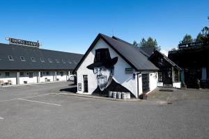 ein Gemälde eines Mannes mit Hut an der Seite eines Gebäudes in der Unterkunft Hotel Laxnes in Mosfellsbær