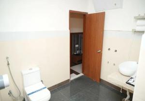 a bathroom with a toilet and a sink at Hotel Orcella in Tirupati