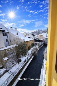 a view from a window of a snow covered city at Penzion na Ostrově in Český Krumlov