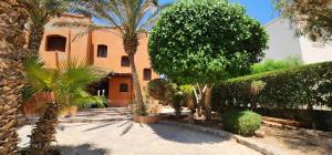 a courtyard with palm trees and a building at Nayah Stays, Lagoons beach, Paradise 3 ensuite with private pool in El Gouna
