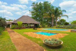 a backyard with a swimming pool and a gazebo at Gallery Inn in Bela-Bela