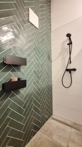 a bathroom with a shower and a tile wall at Haus am FELS, Alpenaster in Hermagor